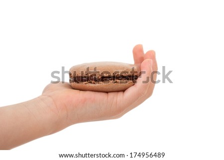Asian child handing a chocolate macaron on white background