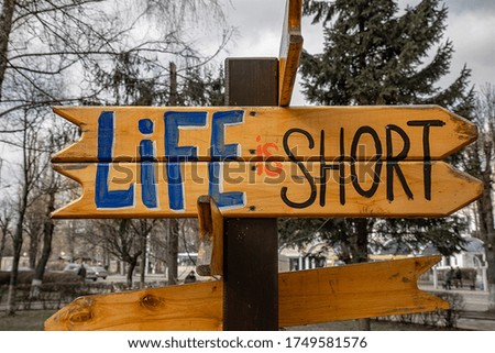 Life is short inscription in the arrow sign drawn by hand. Element of the statue in the public park