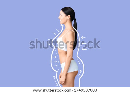 Young woman after weight loss on color background Royalty-Free Stock Photo #1749587000