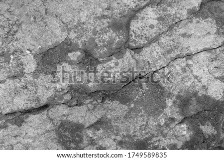 Old concrete cement with cracks and natural destruction from time and weather conditions. Non-color, monochrome black and white photo.