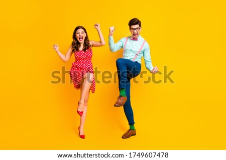 Full length photo attractive lady handsome guy couple win lottery scream astonished raise fists legs wear red dotted dress shirt bowtie retro clothes isolated yellow color background