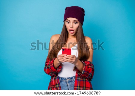 Photo of pretty shocked stylish lady hold telephone hands blogger open mouth read bad news quarantine wear casual hat plaid shirt isolated blue color background