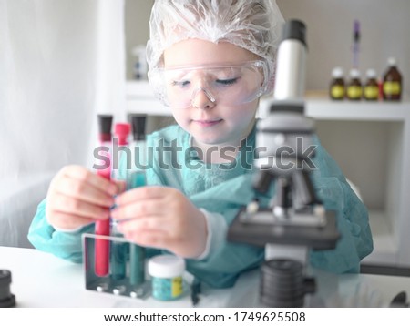 A little girl does scientific work in her home laboratory. The concept is the children of the future. High quality photo