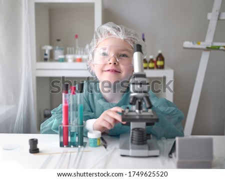 A little girl does scientific work in her home laboratory. The concept is the children of the future. High quality photo