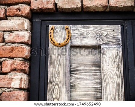 Old wooden door, brick wall and horseshoe