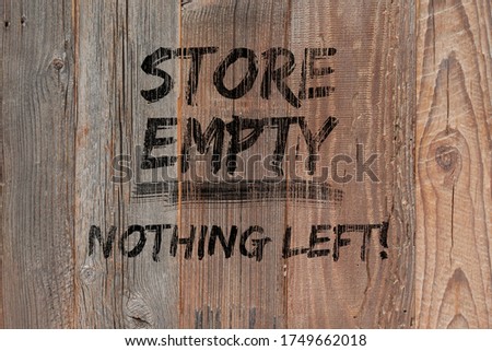 Text "Store empty nothing left" painted black on boarded storefront. Boutique shops and stores boarded up against violence. Aftermath concept with text. Protests, riots and looting in New York City.