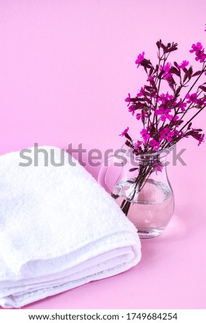 Clean and fresh white cotton towels, Spa treatment with blooming branch on pink background, copy space, spa decoration