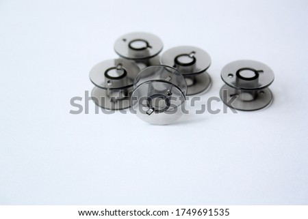 Plastic spools for thread. Black bobbins on a white background.There is free space for text.
