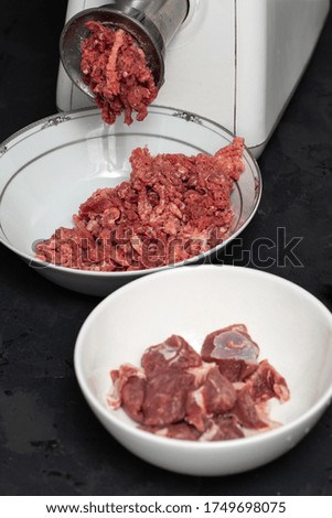 ground meat raw minced and sliced fresh meat in white glass plates and dark background