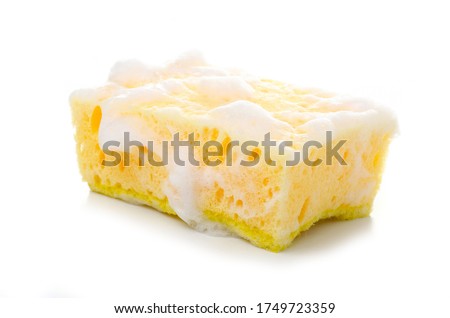 Yellow cleaning sponge in soap foam on white background isolation Royalty-Free Stock Photo #1749723359