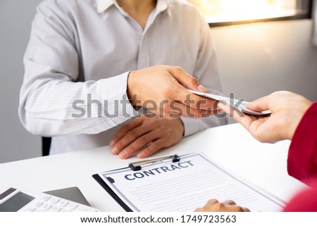 bribery and corruption concept, businessmen offer bribes to business women to sign and manage real estate contracts smoothly.