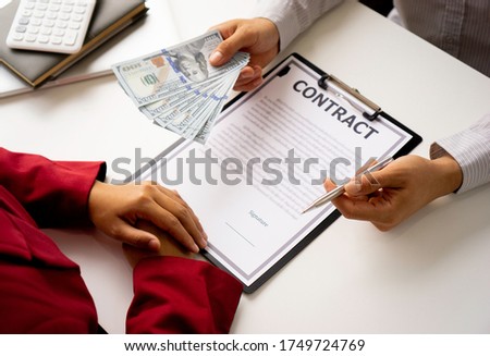 bribery and corruption concept, businessmen offer bribes to business women to sign and manage real estate contracts smoothly.