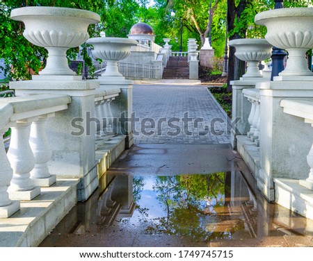 Park with white stairs and vases made of stone.