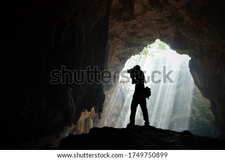 
a photographer photographing stalactites in a cave