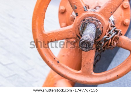 orange iron valve for regulating water flow vertical close-up