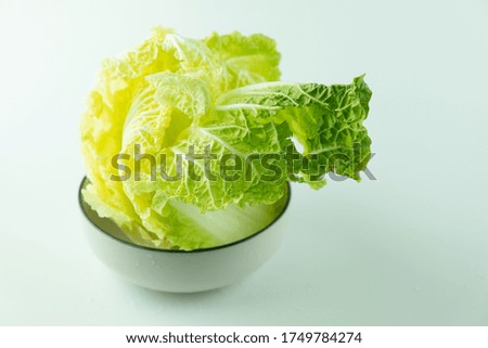 Fresh lettuce leaves in bowl on a white background