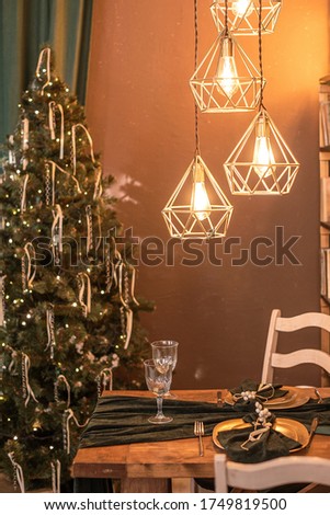 Merry Christmas. Christmas and new year interior. Decorated green Christmas tree, lamps and Christmas table in green pastel colors.