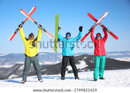 Friends with equipment at ski resort. Winter vacation