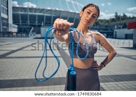 Front view of a fit lady holding her skipping rope in front of the camera Royalty-Free Stock Photo #1749830684