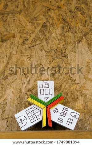Small houses with color roofs over wooden background