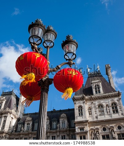 Street light decorated with Chinese traditional red lanterns and Paris City Hall (Hotel de Ville) at backgrounds. Paris celebrates Chinese New Year. 