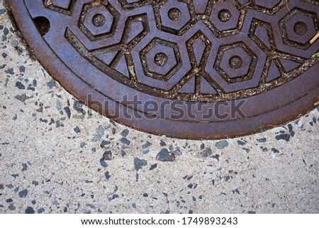 Part of Metal Manhole Cover on the sidewalk. Grunge manhole cover, round edge.