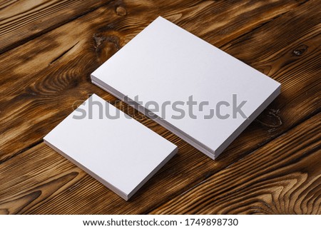 Stack of white business cards on brown wooden background