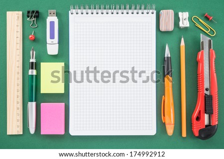 School office supplies on green background  
