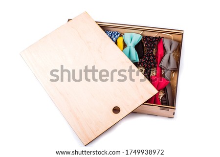 Man selling hand made bow ties. Bow ties in many colors sitting on a table in little boxes.
