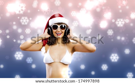 Young Santa girl in white bikini and headphones