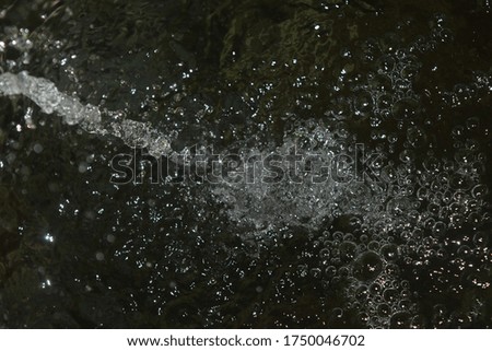 clear sprinkling of water, splash of water, clear water droplets from a running stream of water.