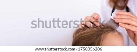Doctor Checking Child Head Hair After Lice Treatment