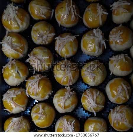 Top view picture of pineapple tart cookies with cheese as topping.