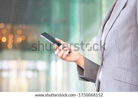 
A working woman who operates a smartphone in the city