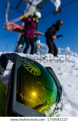 Snow, blue sky. Snowing mountains and skiing man  in ski google reflection