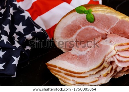 Smoked whole ham in bone with american flag.