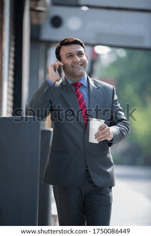 Smiling young businessman calling by mobile phone