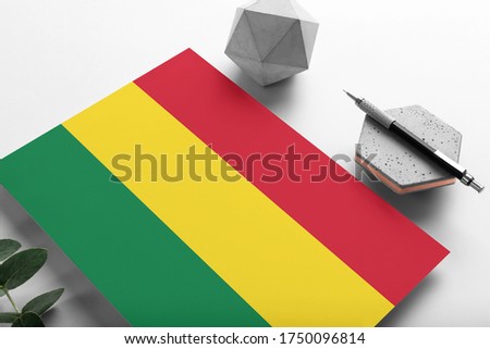 Bolivia flag on minimalist paper background. National invitation letter with stylish pen on stone. Communication concept.