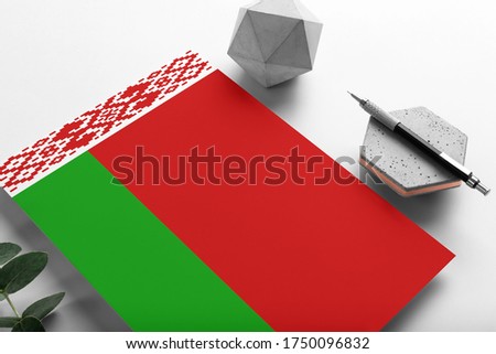 Belarus flag on minimalist paper background. National invitation letter with stylish pen on stone. Communication concept.