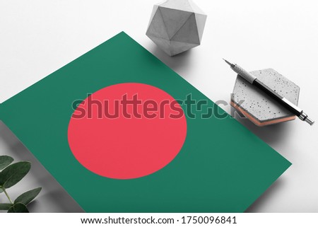 Bangladesh flag on minimalist paper background. National invitation letter with stylish pen on stone. Communication concept.