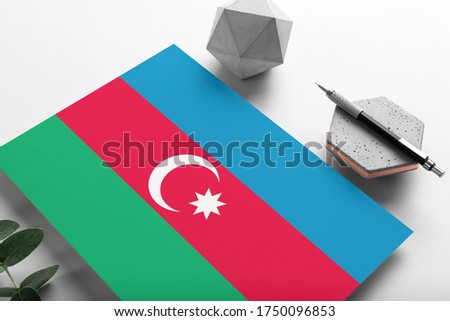 Azerbaijan flag on minimalist paper background. National invitation letter with stylish pen on stone. Communication concept.