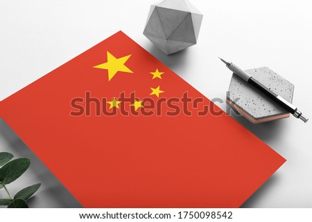 China flag on minimalist paper background. National invitation letter with stylish pen on stone. Communication concept.