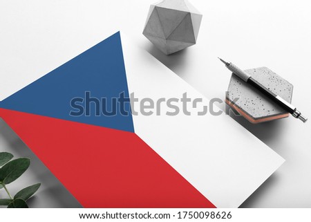 Czech Republic flag on minimalist paper background. National invitation letter with stylish pen on stone. Communication concept.