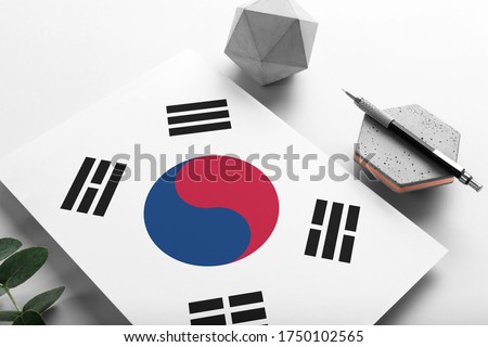 South Korea flag on minimalist paper background. National invitation letter with stylish pen on stone. Communication concept.