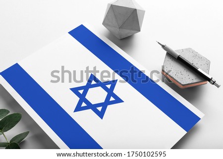 Israel flag on minimalist paper background. National invitation letter with stylish pen on stone. Communication concept.