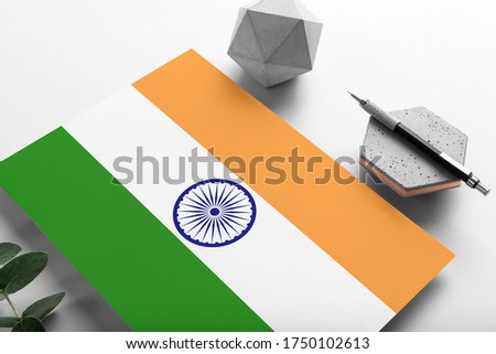 India flag on minimalist paper background. National invitation letter with stylish pen on stone. Communication concept.