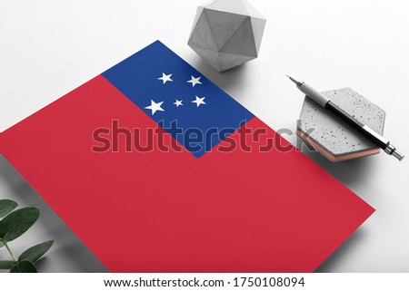 Samoa flag on minimalist paper background. National invitation letter with stylish pen on stone. Communication concept.