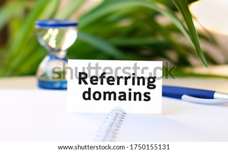 Referring domains - text on a notebook with a spring and a gray handle