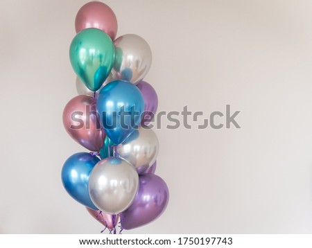 multicolored balloons on the background of a light wall. right-oriented image