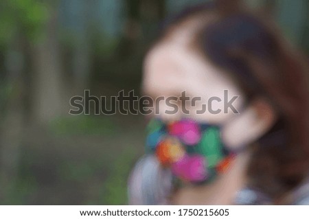 Blurred background. A woman in a protective mask in a recreation Park.